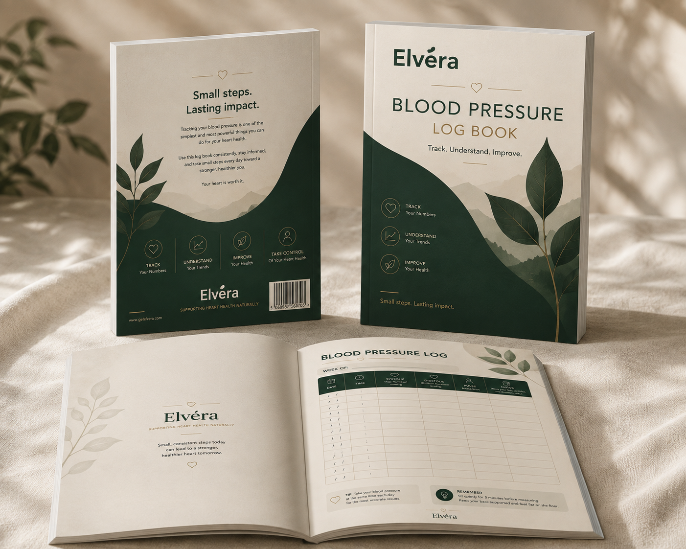Elvéra Blood Pressure Log Book shown in multiple views: standing upright with the back cover, standing upright with the front cover, and open on a cream fabric surface. The book design features dark green and white sections with leaf illustrations and printed text.